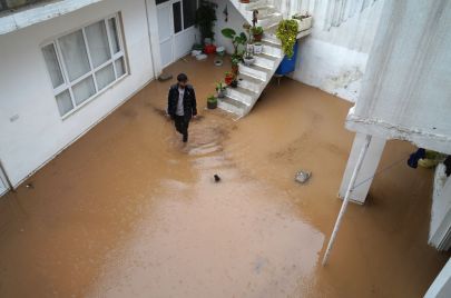 TOPSHOT - A man walks in a flooded courtyard following heavy rains in Dohuk in Iraq's northern autonomous Kurdistan region on March 19, 2024. (Photo by Ismael ADNAN / AFP) (Photo by ISMAEL ADNAN/AFP via Getty Images)