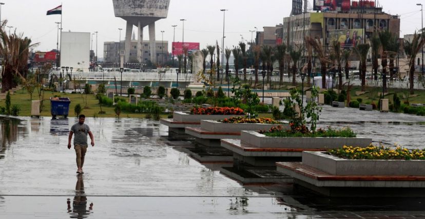 A man walks along a street as heavy rainfall continues in Baghdad on April 12, 2023. (Photo by AHMAD AL-RUBAYE / AFP) (Photo by AHMAD AL-RUBAYE/AFP via Getty Images)