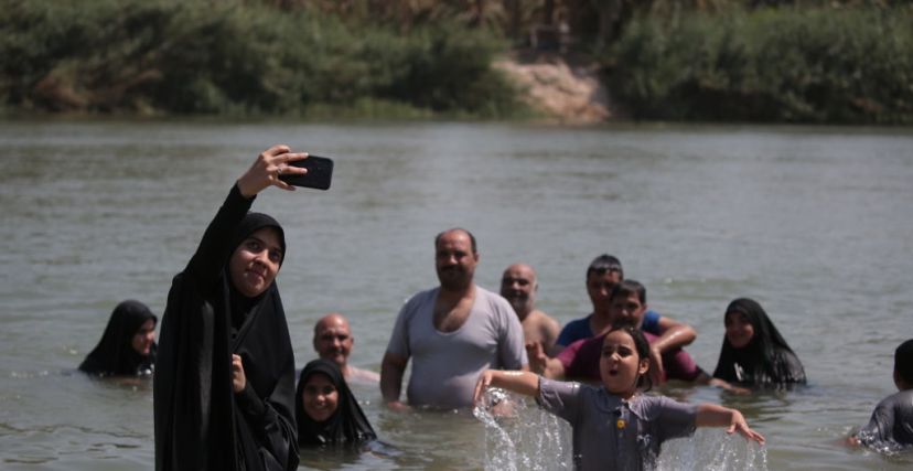 KARBALA, IRAQ - SEPTEMBER 01: People participating in the Arbain march cool off at the Euphrates river during hot weather in Karbala, Iraq on September 01, 2023. Pilgrims from different cities marched on the 40th day of Ashura to commemorate the killing of Imam Hussein, the grandson of the Prophet Muhammad, and 72 people with him in the seventh century. (Photo by Karar Essa/Anadolu Agency via Getty Images)